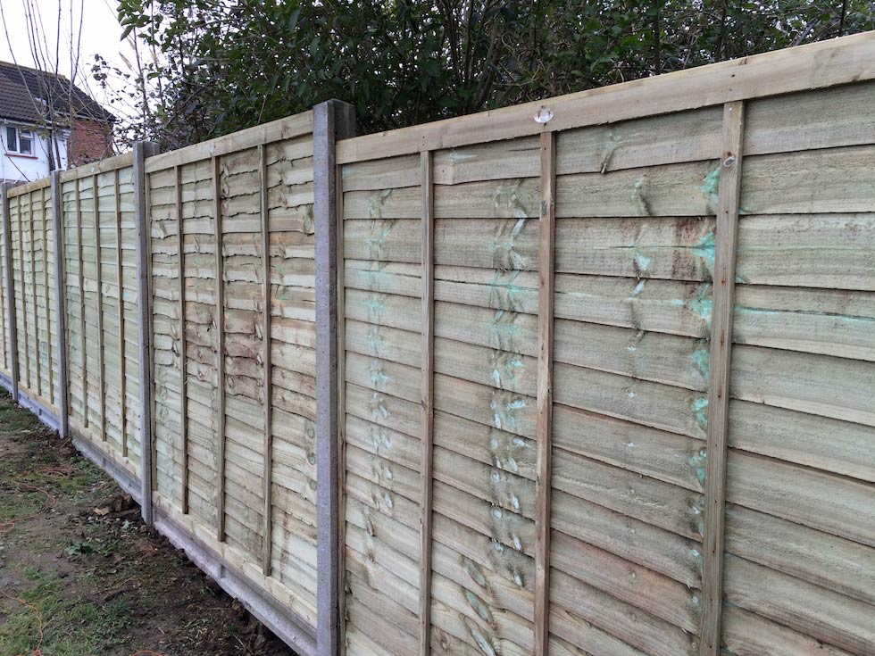 Six-foot lap fencing with concrete posts and gravel boards.